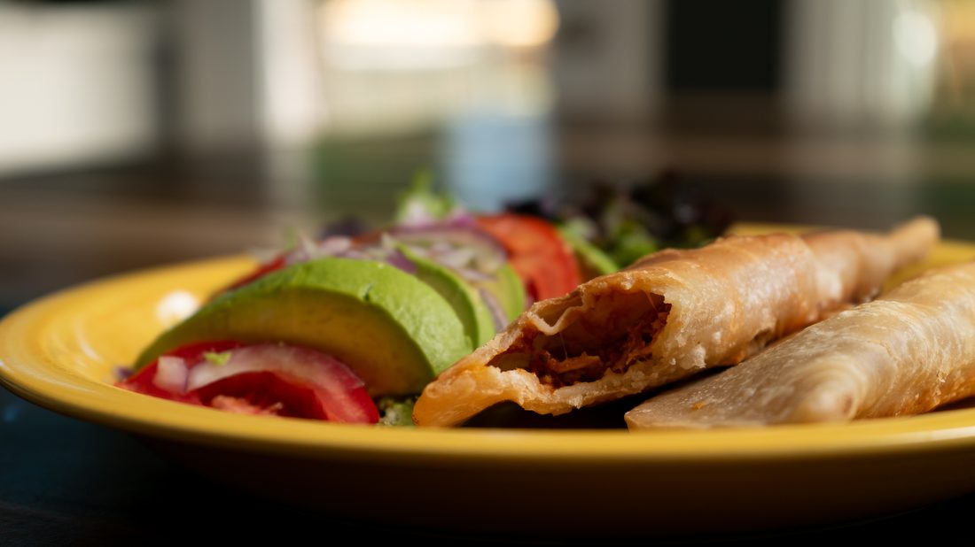 Golden Puerto Rican empanadillas (meat turnovers) on a yellow plate